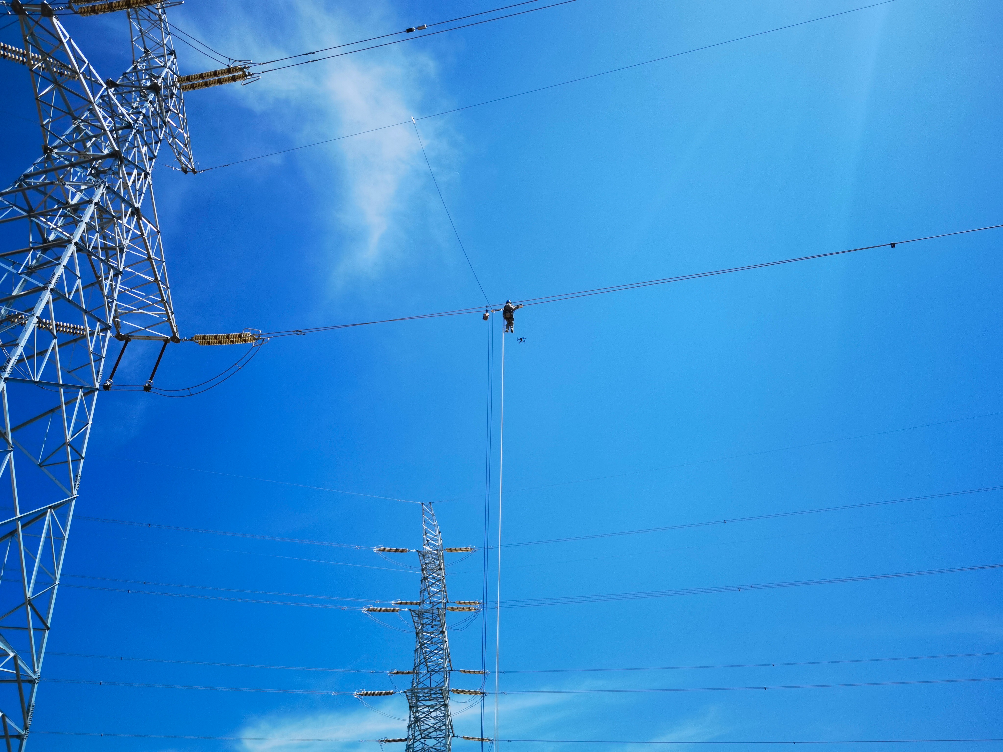 4月12日，在330千伏熙彭一線2號(hào)桿塔春檢現(xiàn)場，國網(wǎng)蘭州供電公司員工采用改進(jìn)的“無人機(jī)掛繩+電動(dòng)升降裝置”<span id=