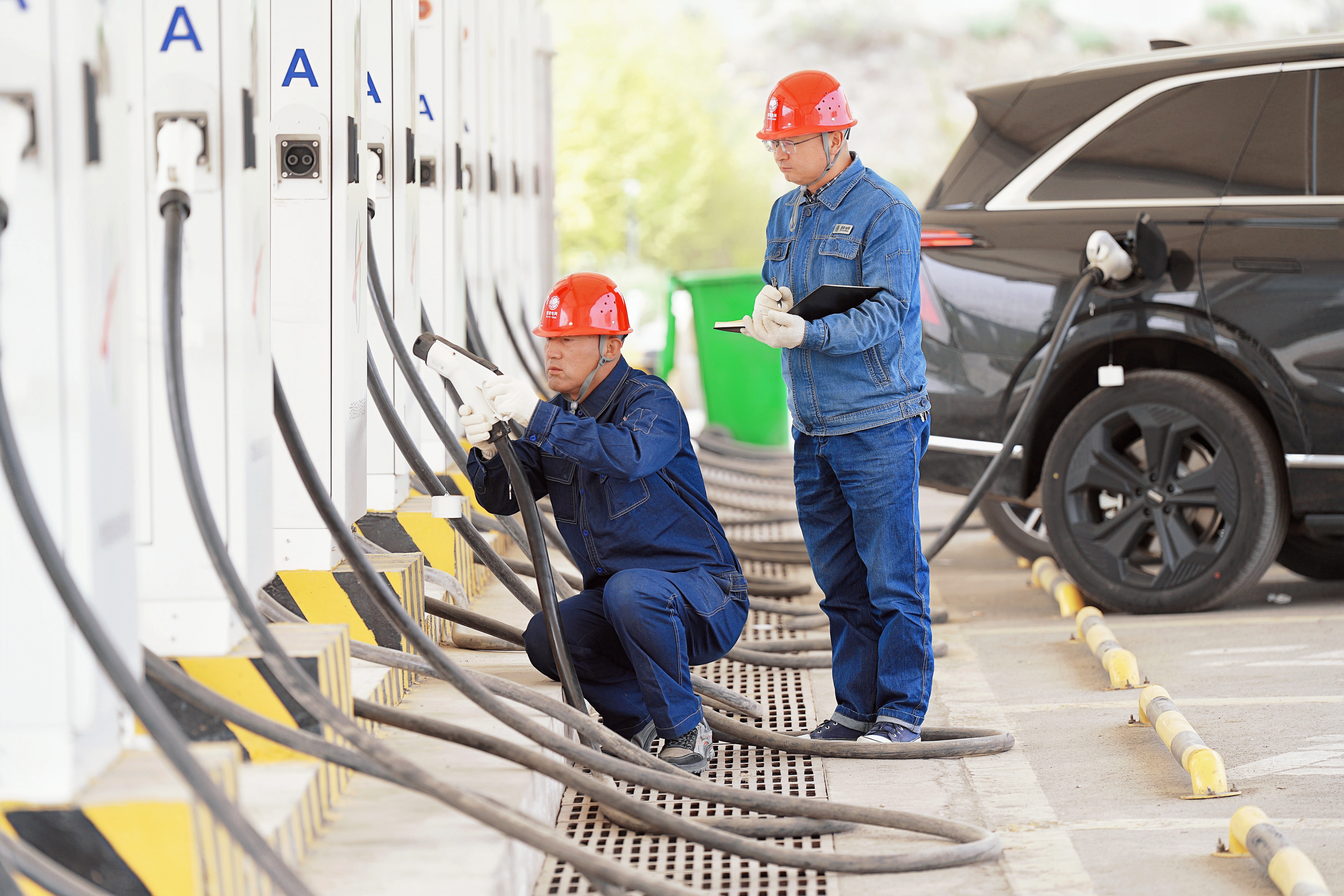 國網皋蘭縣供電公司負荷控制班用電檢查工楊愛名和王小虎巡檢蘭州北服務區(qū)電動汽車充電站，及時消除設備隱患，服務<span id=