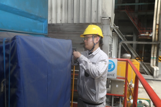 圖為運(yùn)行人員在對(duì)戶外設(shè)備覆蓋防雨篷布.JPG