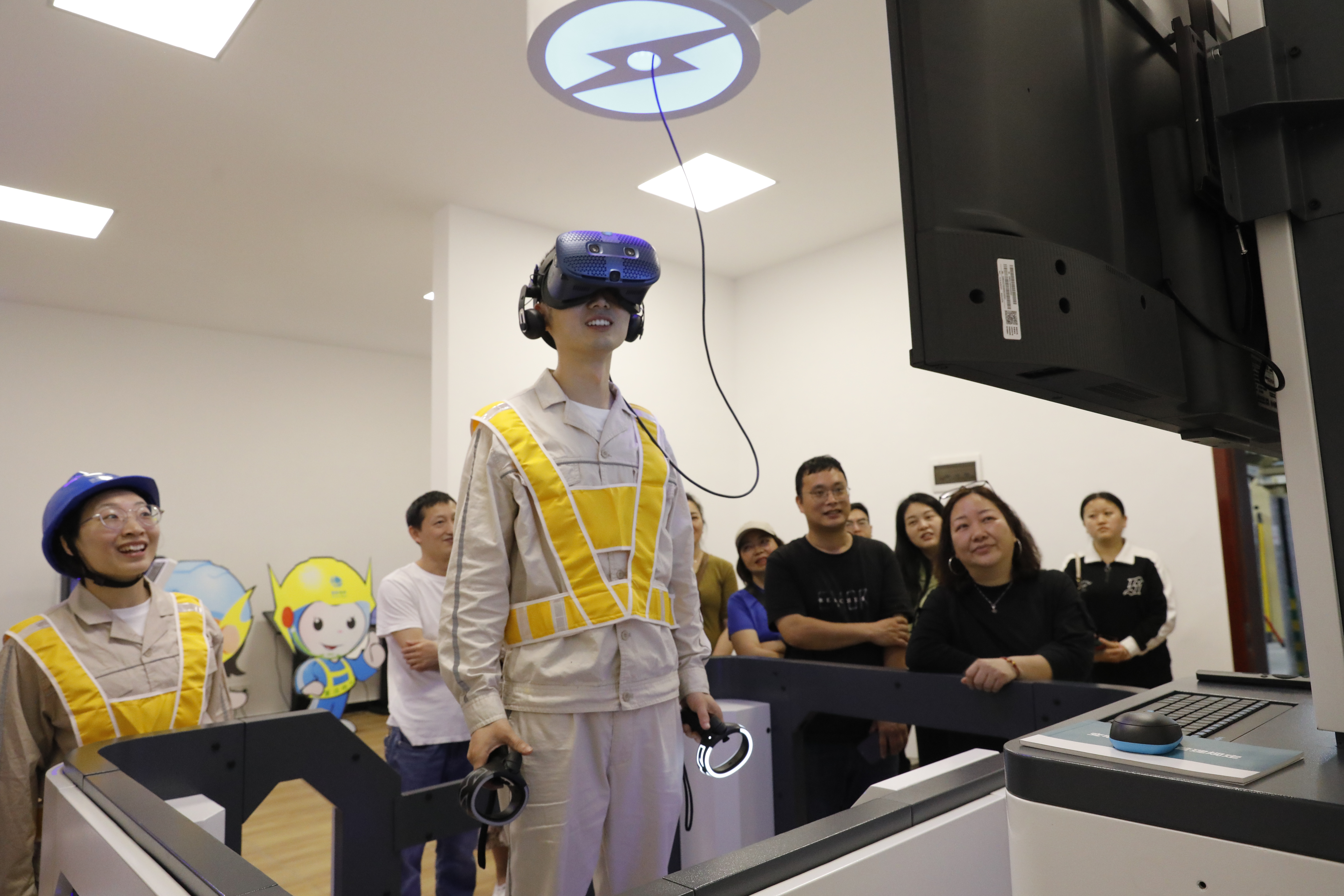 5月10日，國網(wǎng)綦江供電公司工作人員在安全教育室給居民講解電力檢修相關(guān)知識。（袁巧 攝）.JPG