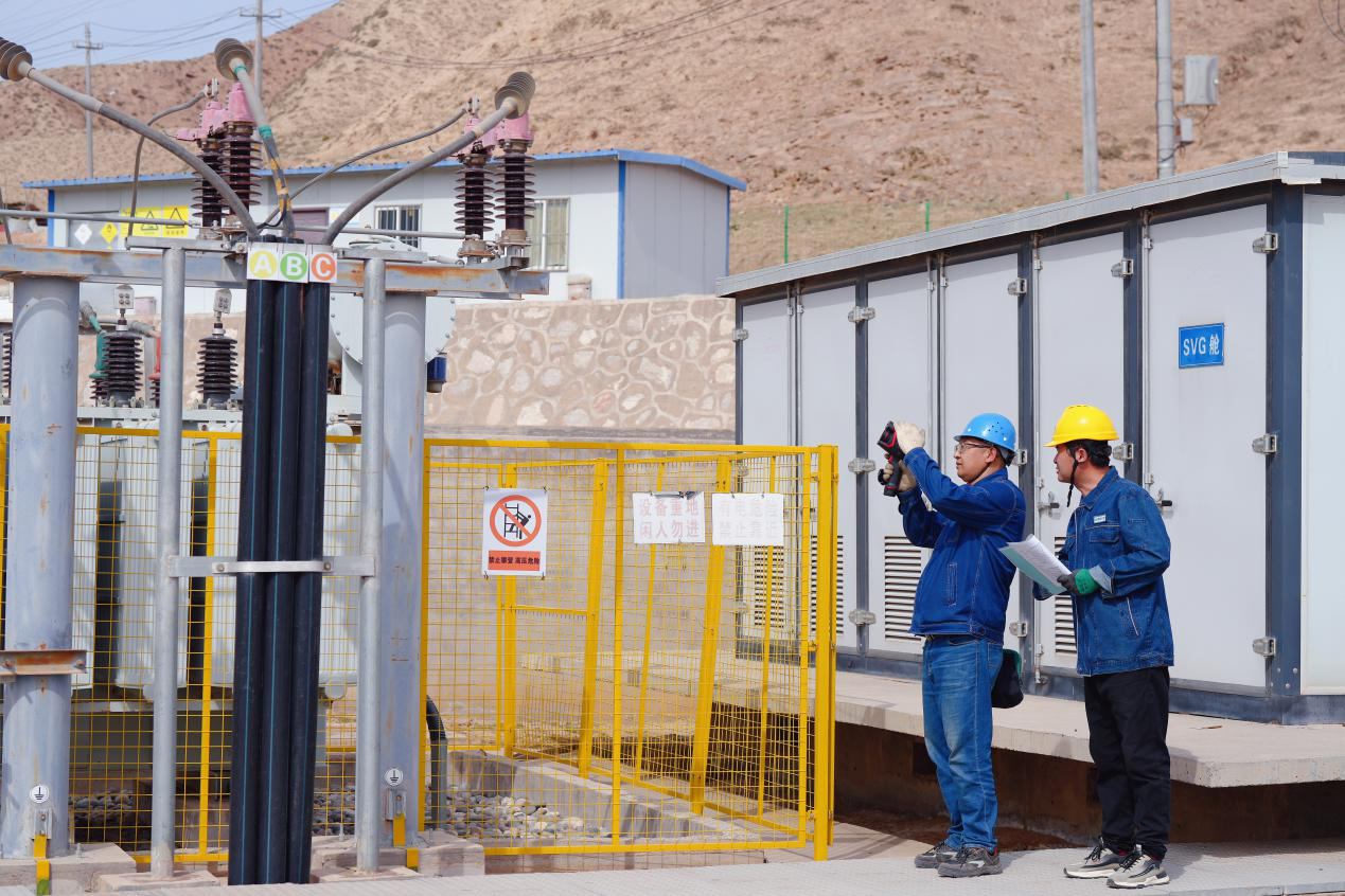 國網(wǎng)永靖縣供電公司員工協(xié)助永靖光輝扶貧光伏電站運(yùn)維人員檢查站內(nèi)供電設(shè)備安全運(yùn)行情況。史雙絢 攝.png